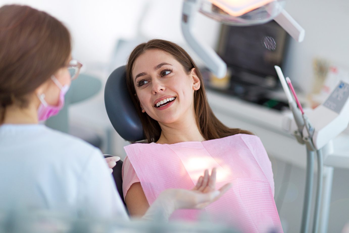 woman talking to dental hygienist during Emergency Dental Care in Medford, MA