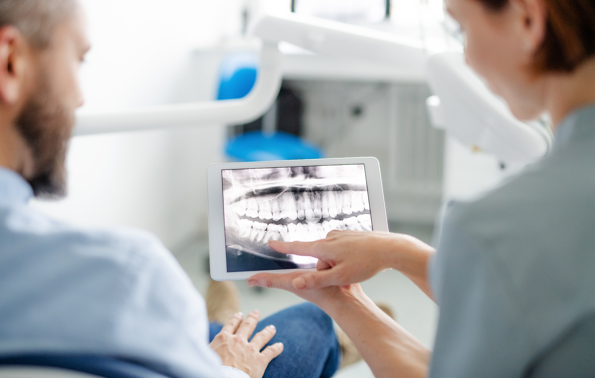 Man at the dentist looking at his dental implant xrays in Medford MA